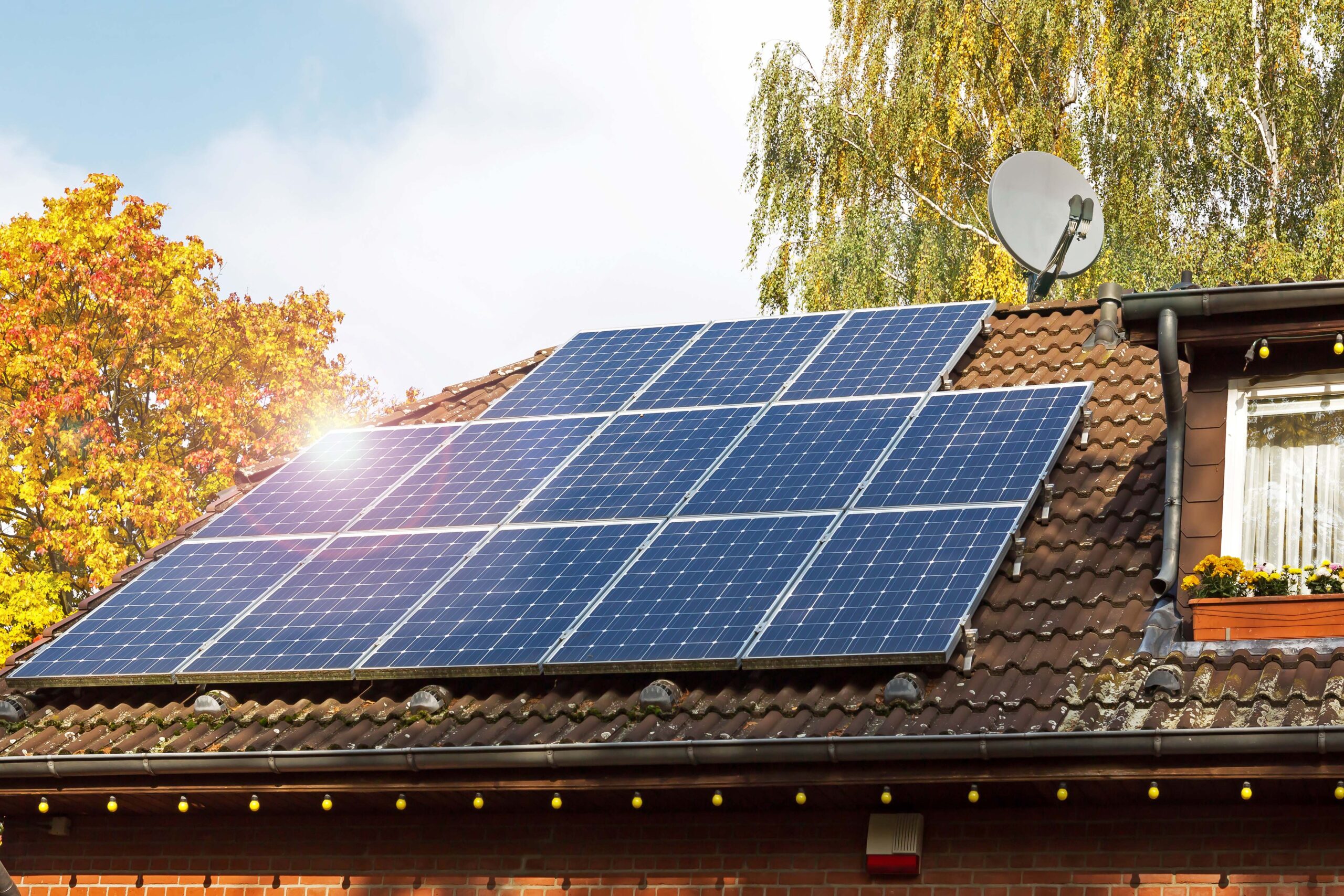 Solarzellen auf Hausdach mit Sonnenreflektion